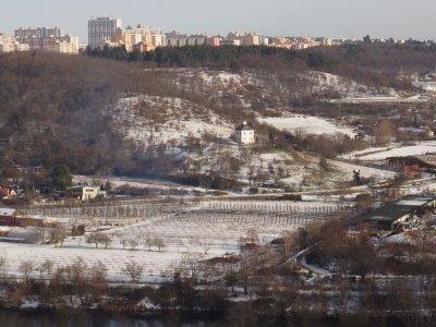 Vyhlídky z vysokého ostrohu Baba v Praze 6 na okolní zasněženou krajinu.